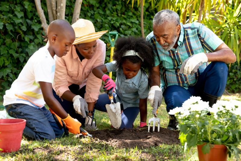 couple spending time with their grand daughter and grandson in the garden 