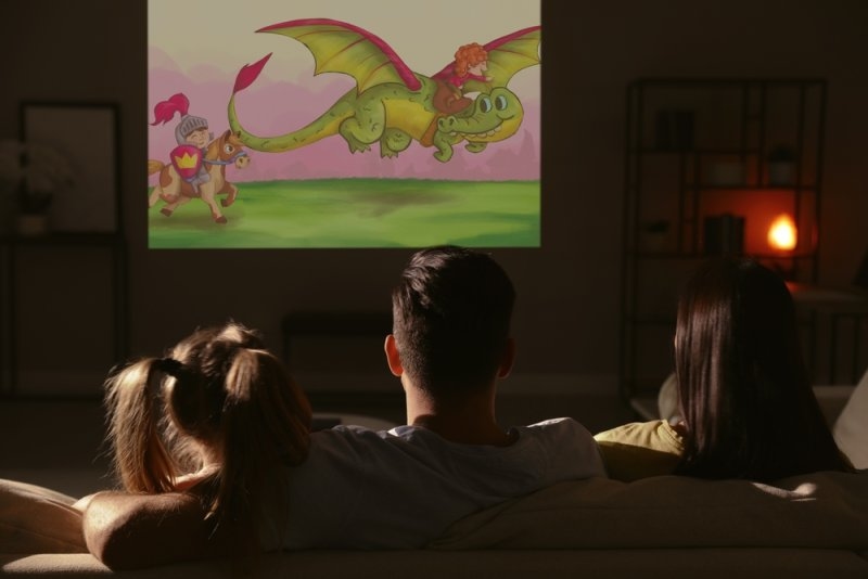 A family watching an animated fantasy cartoon together on television at home.