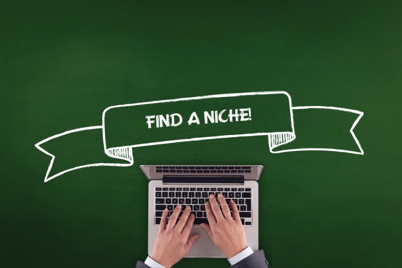 A laptop with hands typing beneath a green banner reading “Find a Niche!”