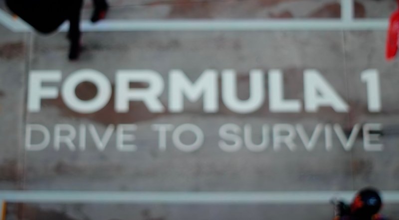 Blurred Formula 1-themed sign displaying the words “FORMULA 1” and “DRIVE TO SURVIVE.”