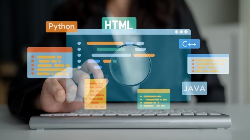 Person working on a laptop with graphic overlays representing programming languages such as Python, HTML, C++, and Java.
