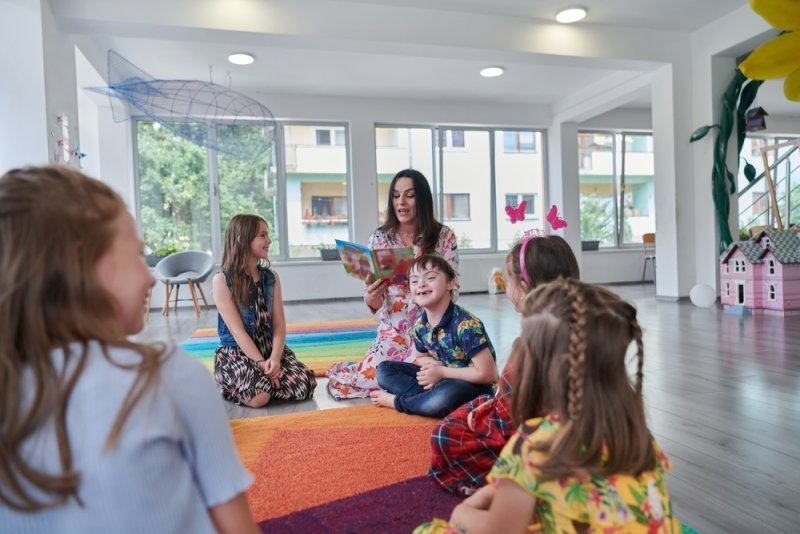 Reading time in an elementary school or kindergarten, a teacher reading a book to children in an elementary school or kindergarten. 
