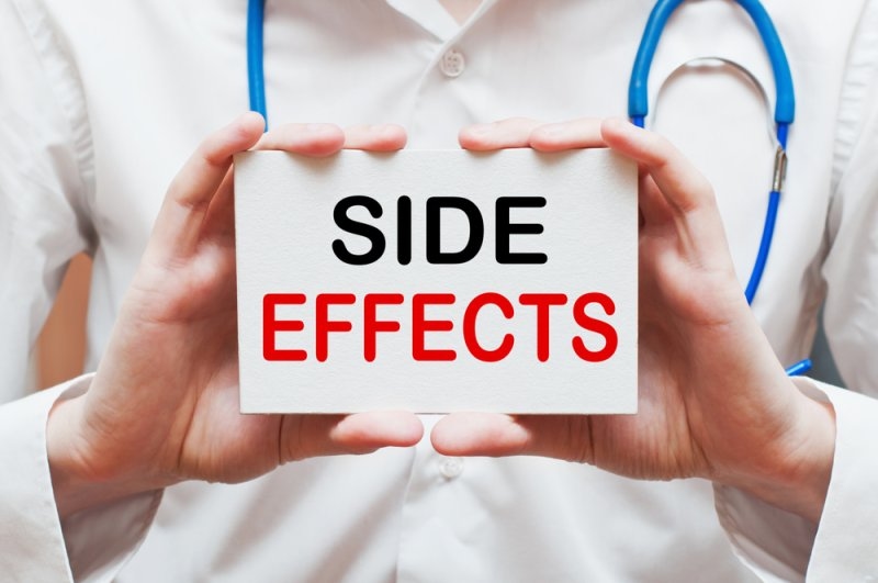 A doctor holding a paper and "side effects" written on it.