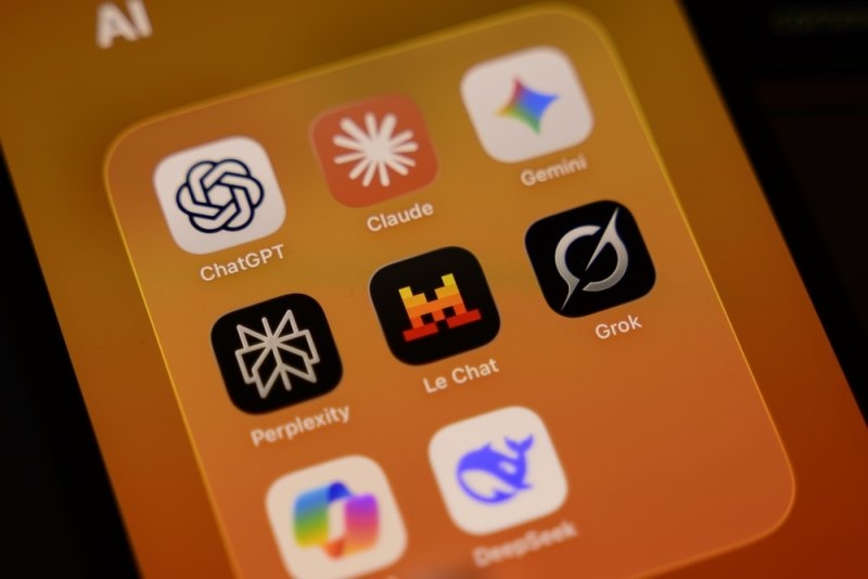 Smartphone screen showing an AI apps folder with ChatGPT, Claude, Gemini, Perplexity, Grok, and other AI tools.