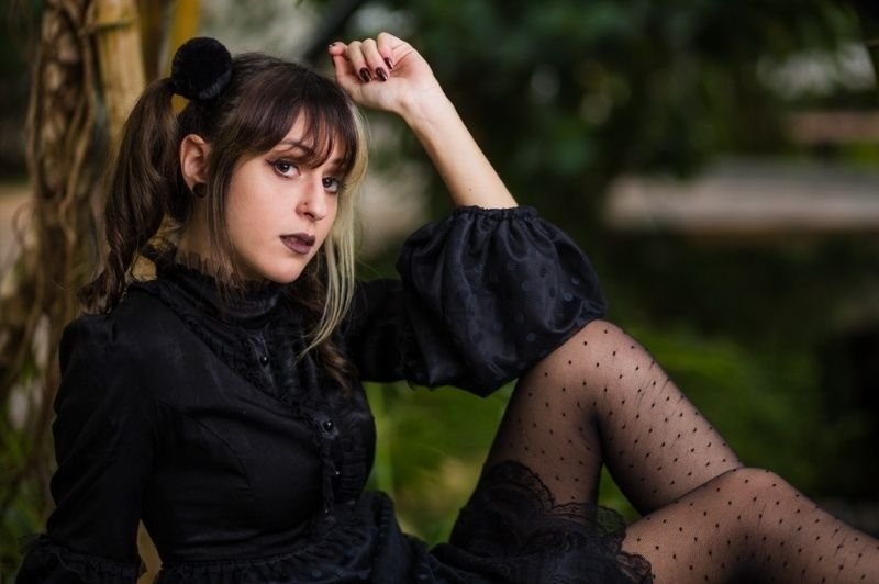 A young woman poses outdoors in a gothic-inspired outfit.