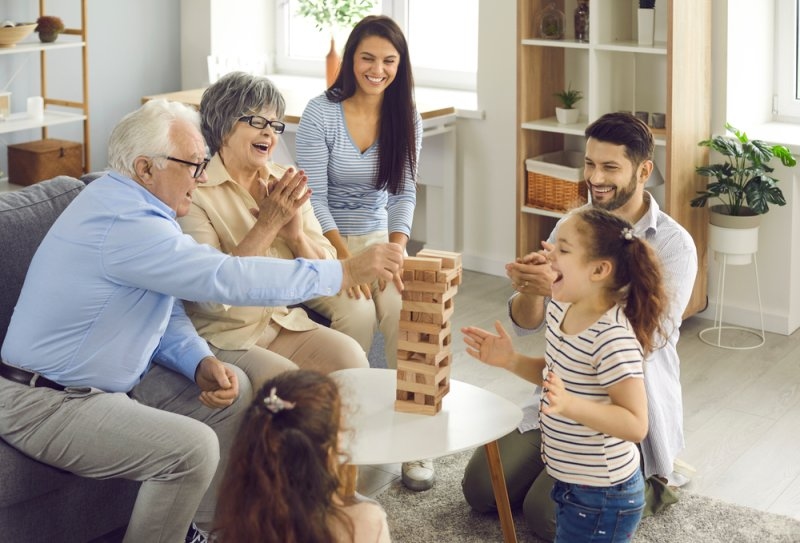 Happy big family with little children enjoying the weekend at home, playing board games