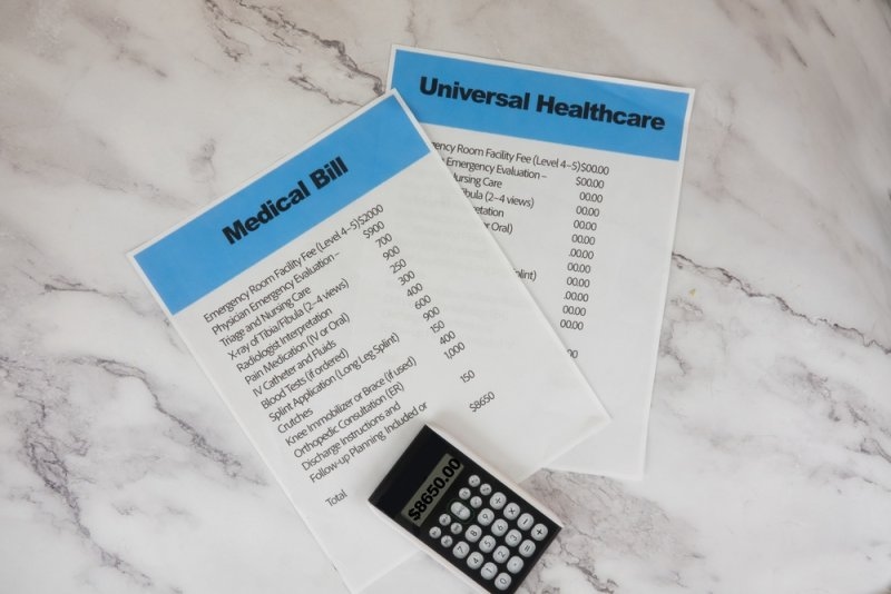 Medical bill and health insurance documents beside a calculator, representing healthcare costs and plan comparisons.
