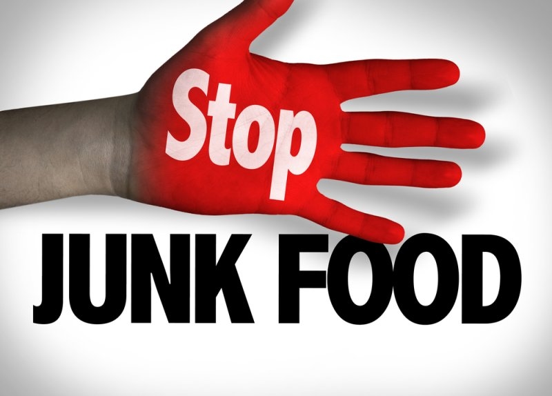 Red hand with the word “Stop” displayed above bold text reading “JUNK FOOD.”
