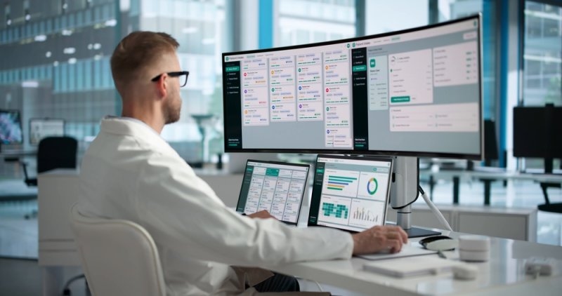 Healthcare professional reviewing digital patient records and medical information dashboards.