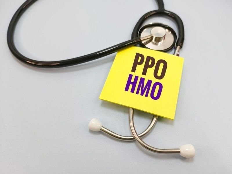 Stethoscope with a sticky note labeled "PPO HMO".