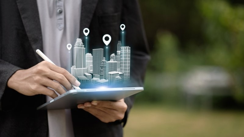 A person uses a tablet to project a holographic 3D model with location markers.