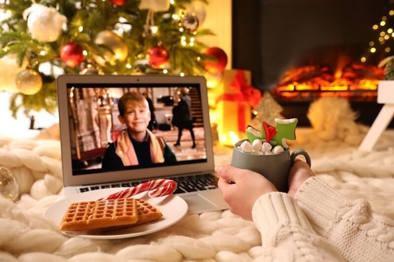 family watching home alone movie in laptop on christmas eve