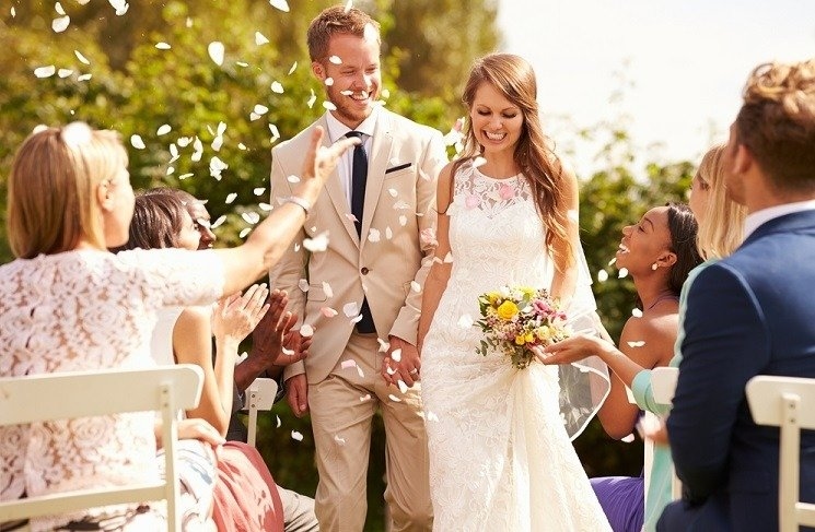 bride and groom happily walking and guests cheering them up