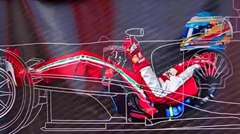 A Formula 1 driver seated inside a race car cockpit, wearing a red racing suit and helmet.