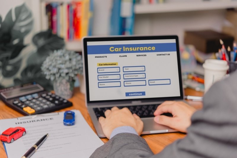 man checking his car insurance quote on his laptop