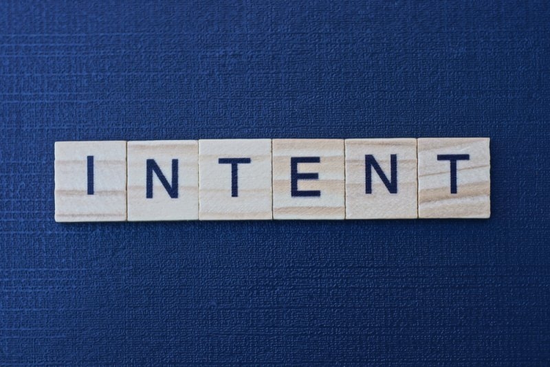 text on word intent from gray wooden letters