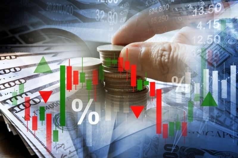 “Stacking coins on top of U.S. dollar bills with overlaid stock market charts and percentage indicators, representing investing and financial growth.