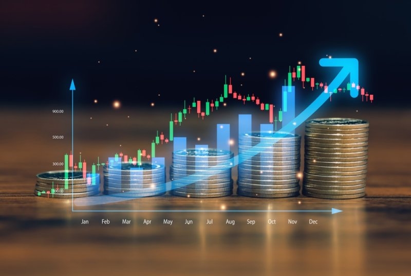 Stacks of coins increasing in height alongside a rising stock market chart and upward arrow, illustrating investment growth.