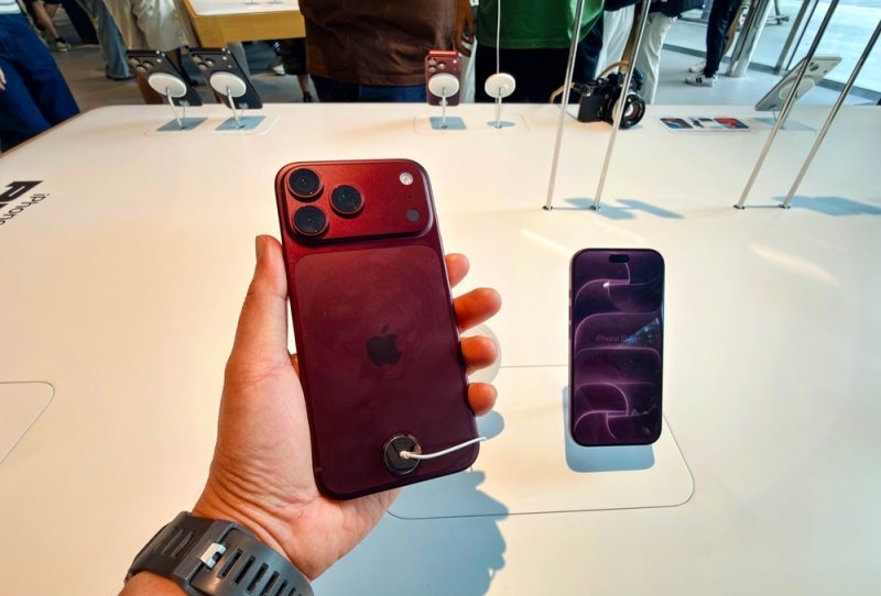 A red iPhone displayed in a retail store.