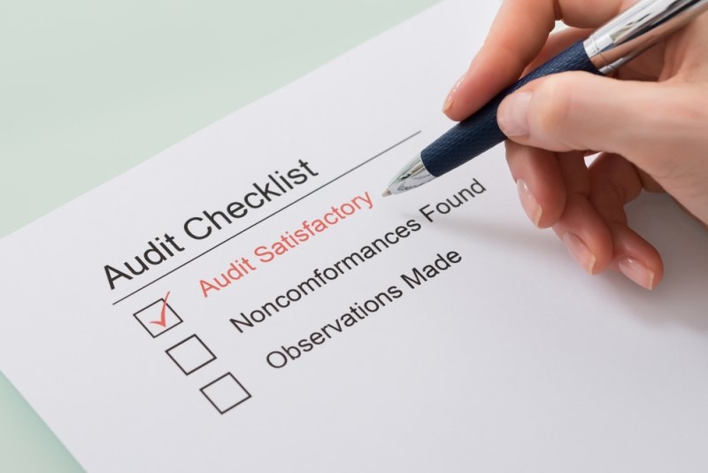 Professional reviewing an audit checklist as part of an information security compliance assessment.