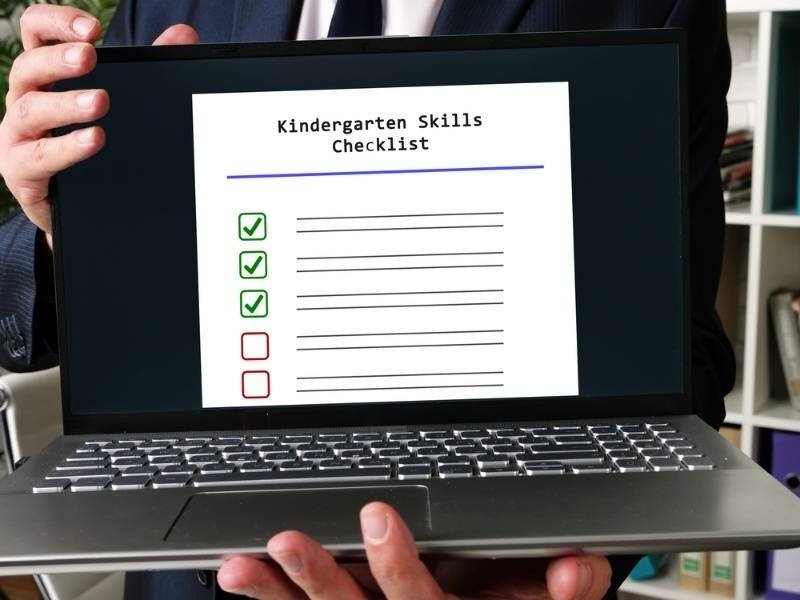 Laptop displaying a kindergarten skills checklist with completed and pending items.