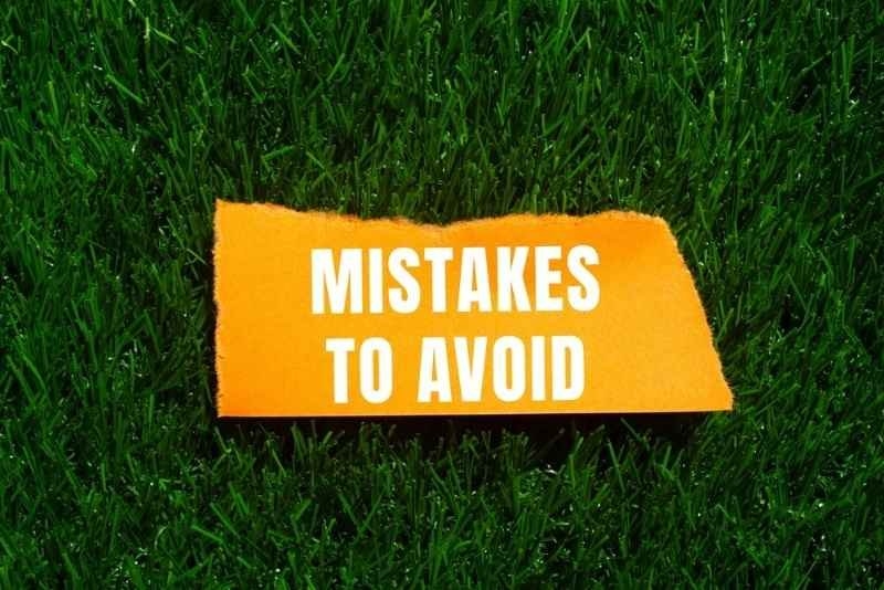Mistakes to avoid message written on ripped torn paper with a grass background.