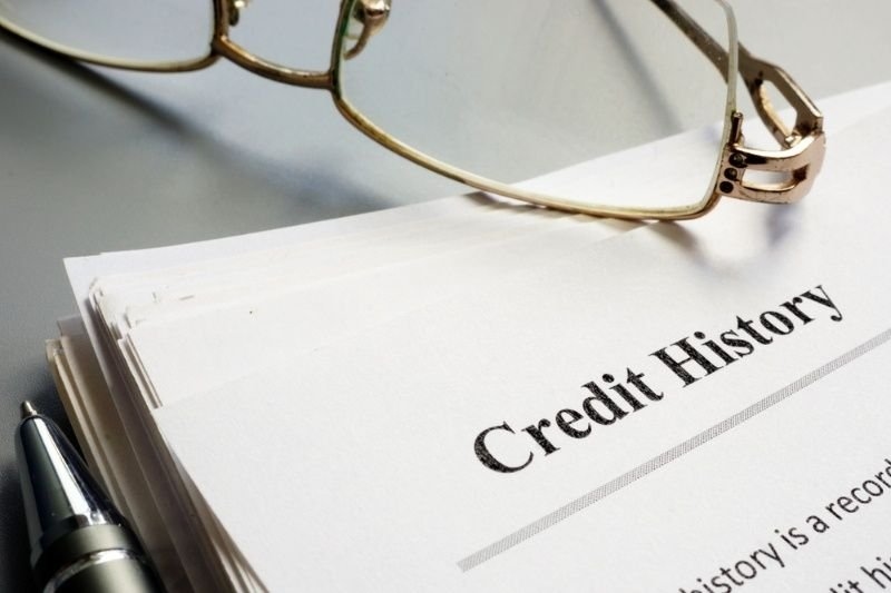 Close up look of Credit history report papers, pen, and reading glasses.