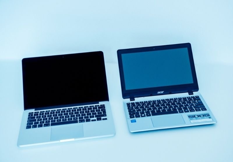 Apple macBook pro and Acer Aspire Windows PC side by side on a white background.