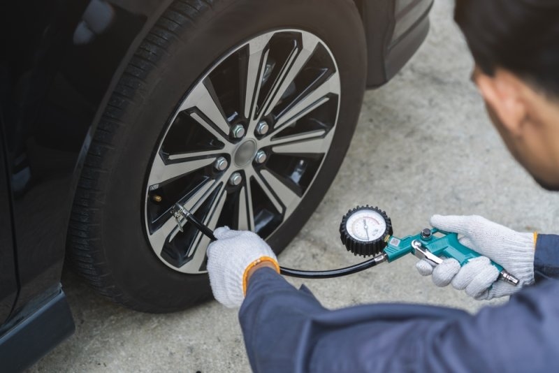 man checking tire measure