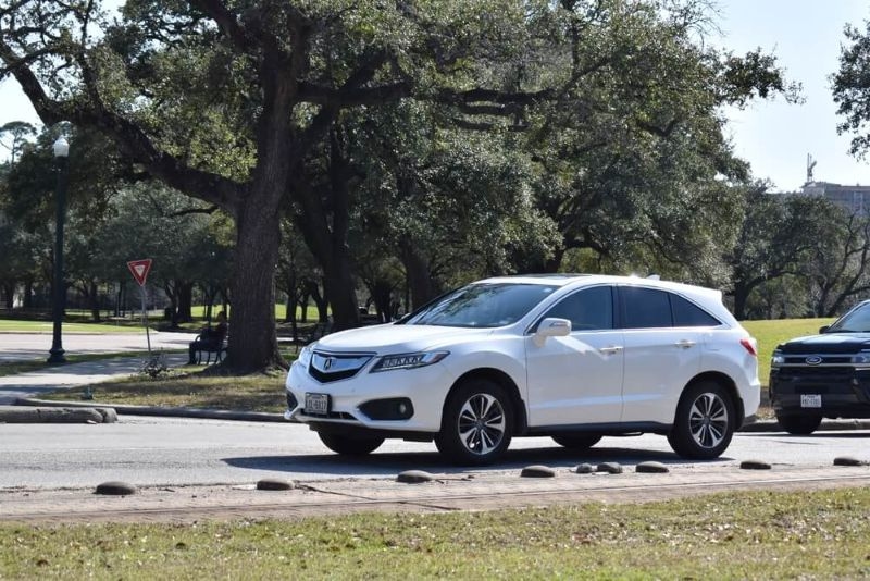 Acura Mdx in white in front of a ford car