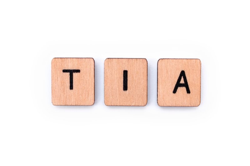 The abbreviation TIA - meaning Transient Ischemic Attack - the medical term for a mini-stroke, spelt with wooden letter tiles over a white background.