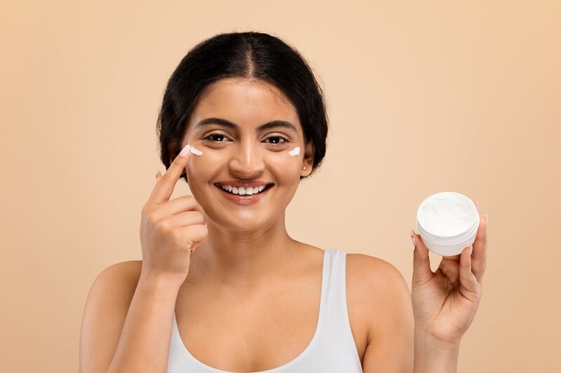 woman applying moisturizer on skin