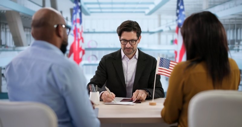 Family Consults An Immigration Lawyer For Their USA Visa Application Process. A Couple Reviews Documents.
