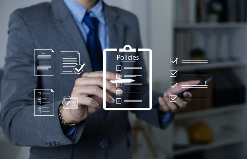 Business professional reviewing policy documents and compliance checklists using digital document icons.