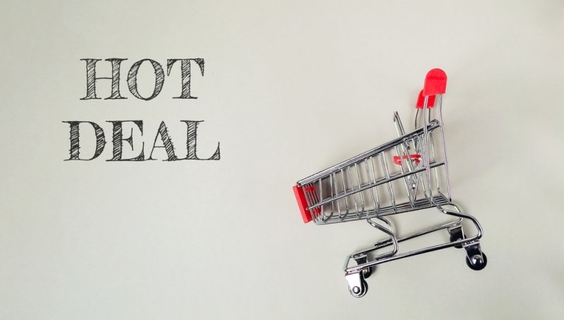 Shopping cart with the word HOT DEAL written on it. The cart is made of metal and has a red handle.