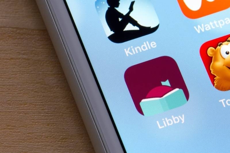 Close-up of a tablet screen showing e-reading apps like Kindle and Libby.
