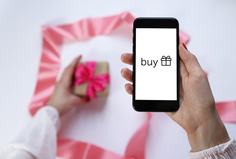 Gift and phone in female hands