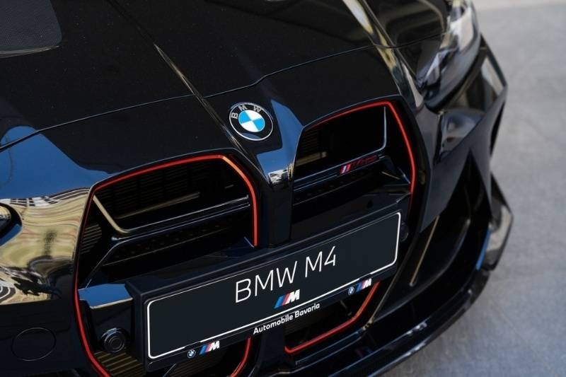 Close-up of the front grille and badge of a black BMW M4.