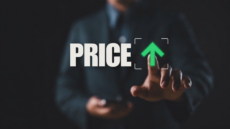 A business professional interacting with a digital graphic showing the word “PRICE” and an upward green arrow.