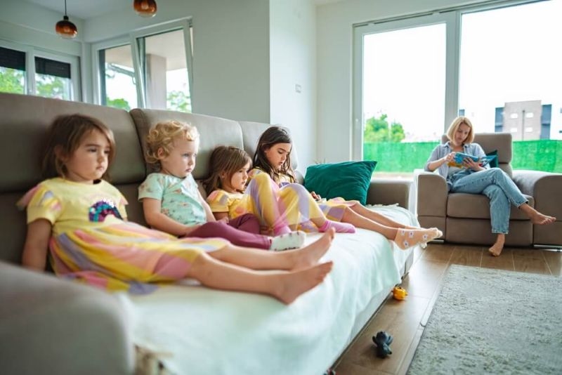 Small kids watching tv sitting on sofa