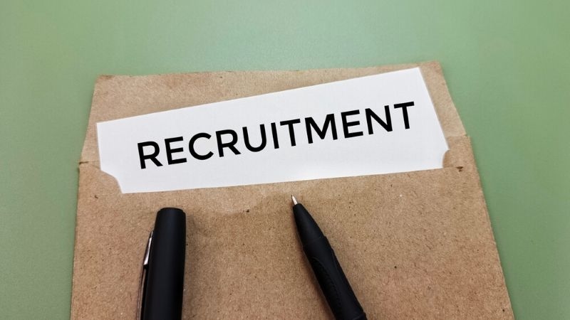 Recruitment word on paper in brown Envelope with black pen 