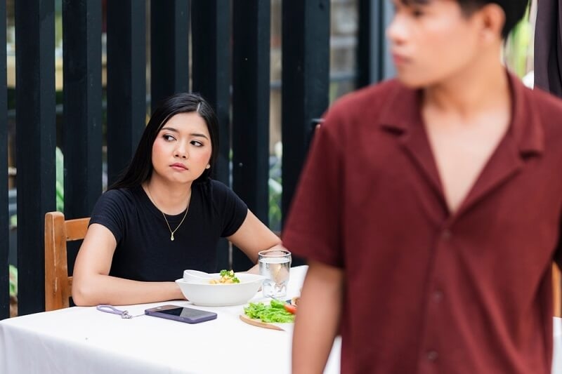 woman with angry face sitting on chair after having argument with boyfriend
