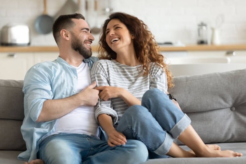 Couple sitting on a sofa and laughing together