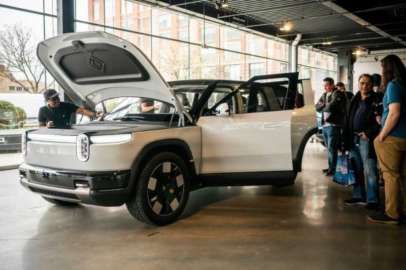 Fans of Rivian electric vehicles view a prototype of the Rivian R2 at Rivian Spaces.