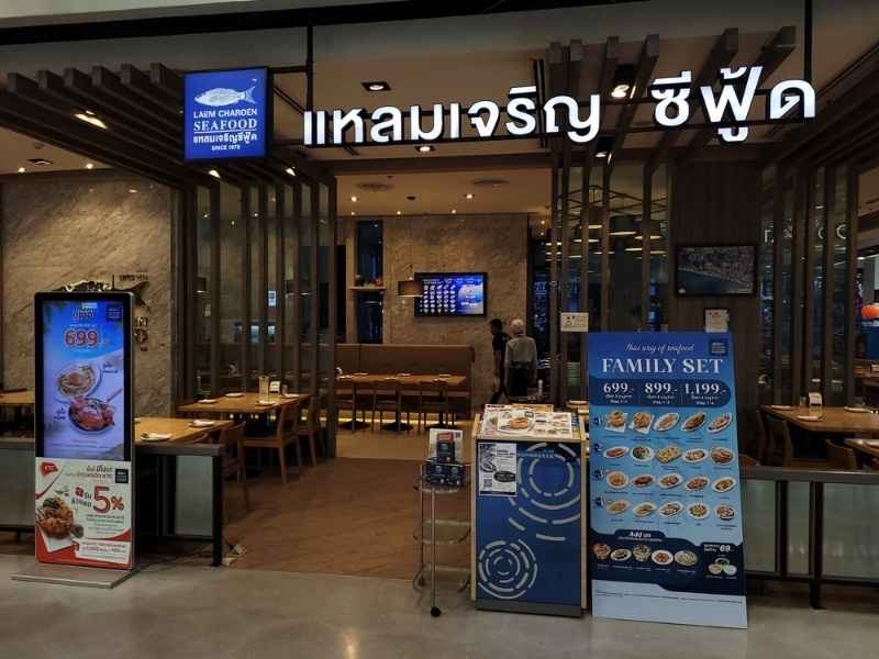Seafood restaurant entrance inside a shopping mall with menu displays and dining tables.