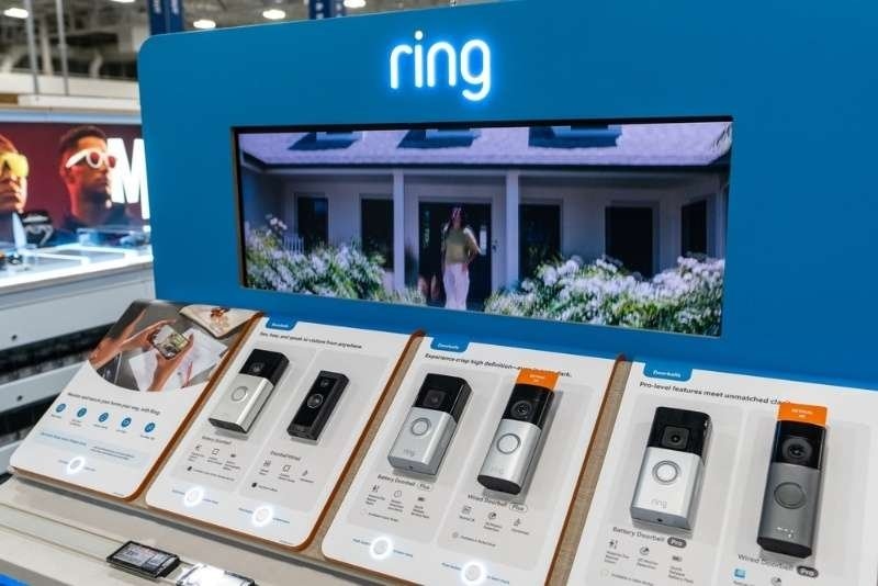 Ring smart home security products displayed in a retail electronics store, including video doorbells and home monitoring devices.