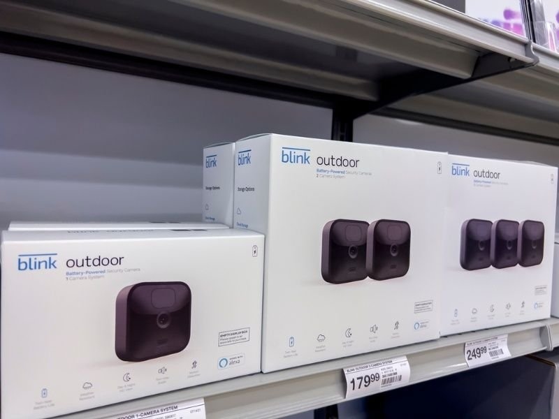 Blink outdoor security camera packages displayed on store shelves, featuring smart home surveillance systems.