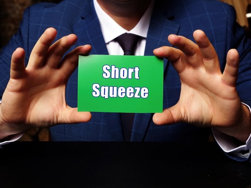 trader holding short squeeze text card in hand