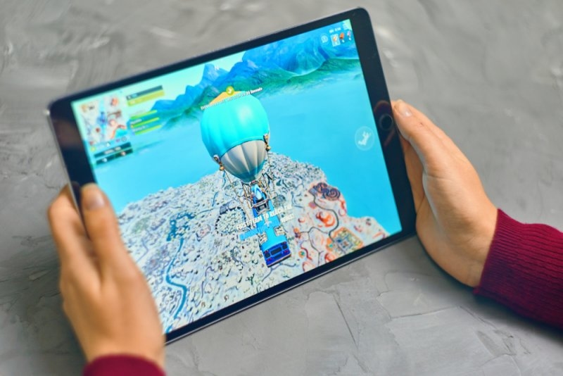 man playing fortnite game on his ipad
