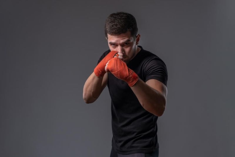  young fighter with wrapped hands standing in orthodox stance